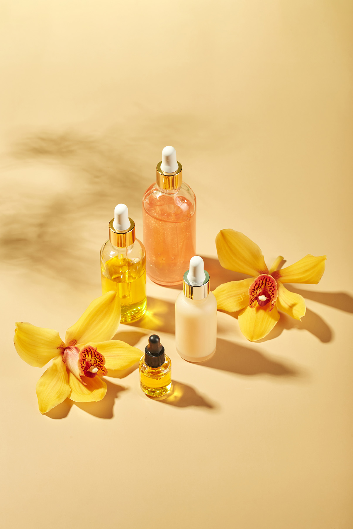 Create a skincare campaign with golden light, glass bottles, and fresh orchids.