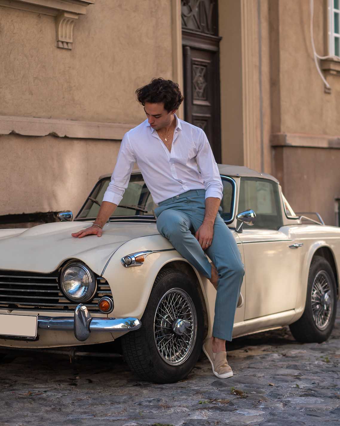Shoot a fashion editorial beside a vintage convertible on an Italian street.
